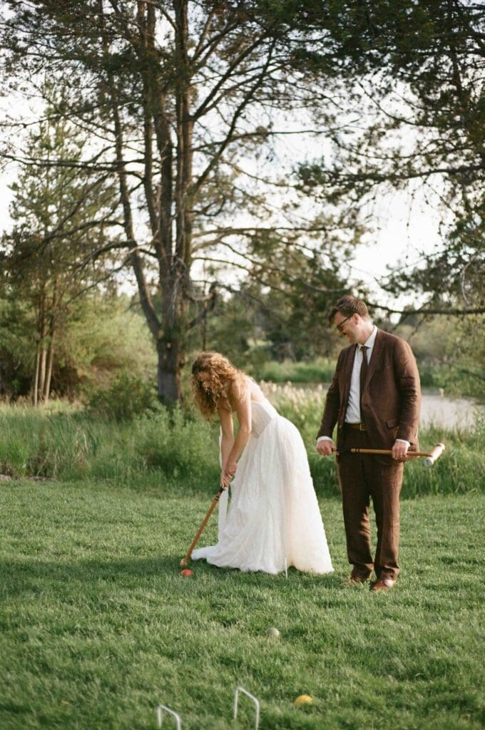 Bride and groom playing a game of croquet on the lawn at their Sunriver Resort wedding.
