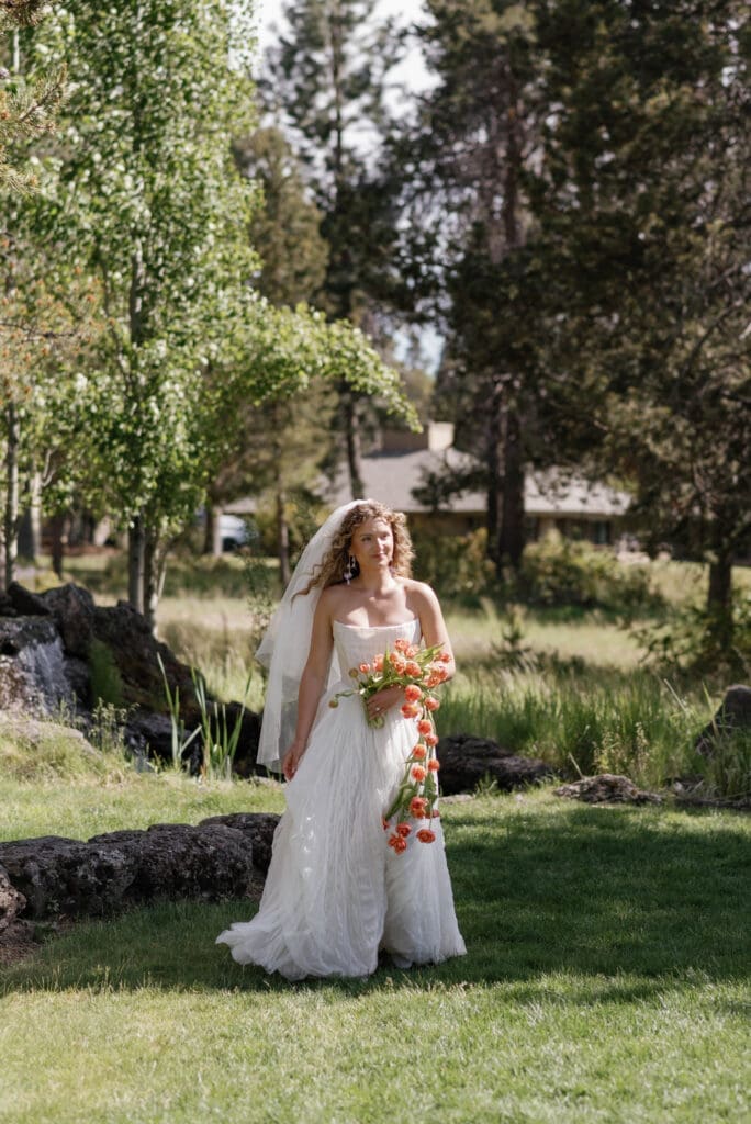 Wide black and white shot of the outdoor ceremony with seated guests and mountain backdrop, Sunriver Resort wedding, Central Oregon.