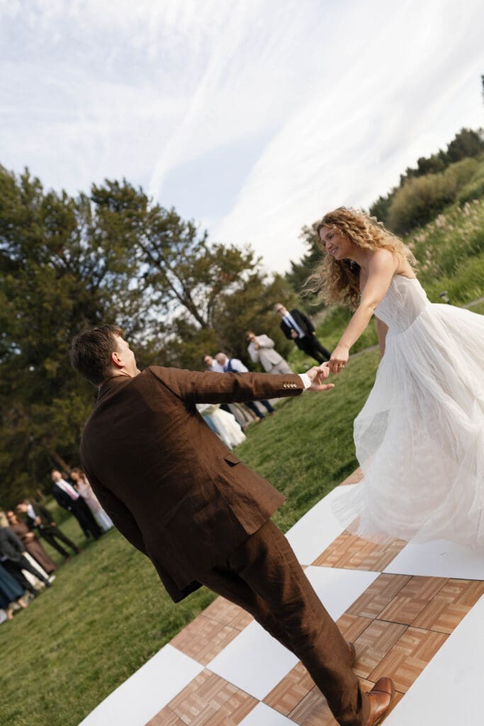 Playful moment on the checkered dance floor as guests look on during wedding reception, Central Oregon.